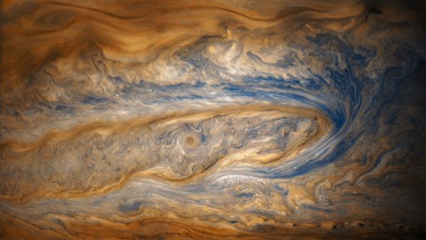 in this older view of jupiter from junos eighth perijove two cloud bands battle for dominance one of which contains a swirling storm many times larger than a hurricane on earth