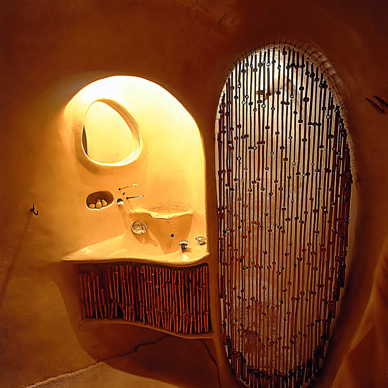 the bathroom features a sculptural sink and shower