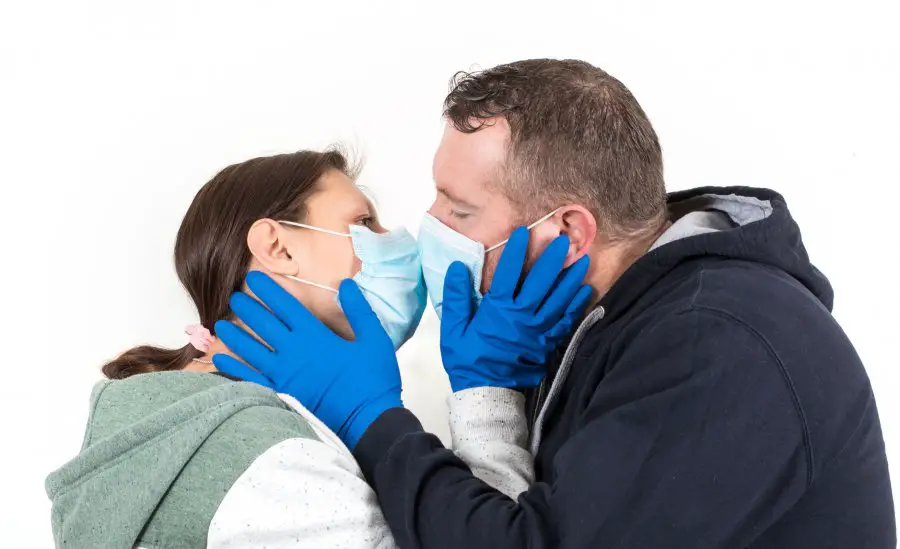 Couple wearing a virus face mask kissing concept for corona viru
