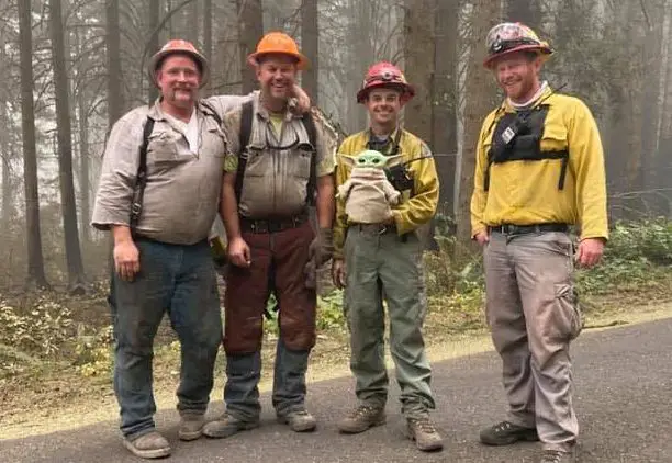 firefighters with a baby Yoda doll