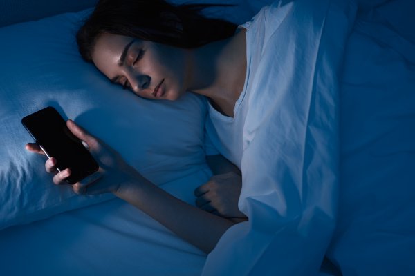 woman sleeping with smartphone in bed 2022 11 12 14 58 28 utc